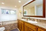 First floor bathroom, located across the hall from the laundry room, features double sinks and a soaking tub